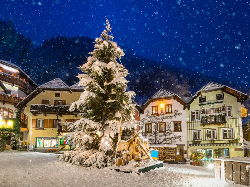 The Marktplatz in Hallstatt under snow at night, the Christmas tree lit